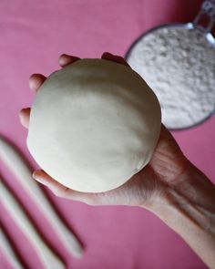 a person holding a ball of dough in their hand