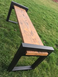 a wooden bench sitting on top of a lush green field