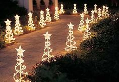 christmas lights in the shape of trees and stars are lit up on a path at night