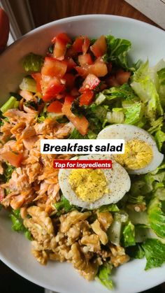 breakfast salad with hard boiled eggs, lettuce and tomatoes on top in a white bowl