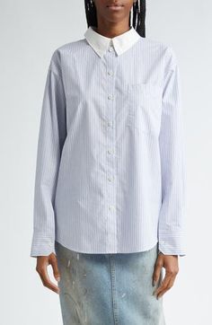 The Swedish label puts its signature streetwear spin on a wardrobe-essential button-up cut from striped cotton poplin and refreshed with a contrasting collar. An unexpected button placket at the back furthers the statement-making design. 28 1/2" length (size 36 EU) Front button closure Spread collar Long sleeves with button cuffs Chest patch pocket Curved hem 100% cotton Machine wash, line dry Imported Designer Clothing Pinstripe Cotton Shirt For Work, Pinstripe Cotton Button-up Shirt, Pinstripe Cotton Shirt With Button Closure, Pinstripe Shirt With Button Closure For Daywear, Cotton Shirt With Vertical Stripes For Daywear, Workwear Button-up Shirt With Signature Stripes, Button-up Shirt With Signature Stripes For Work, Cotton Tops With Signature Stripes For Work, Cotton Striped Tops For Work