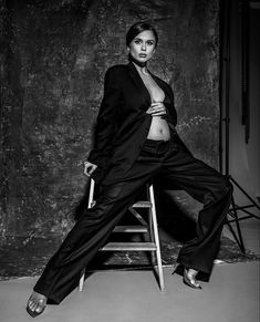 a black and white photo of a woman sitting on a chair