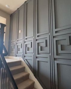 a stair case next to a set of stairs in a room with gray walls and white carpet