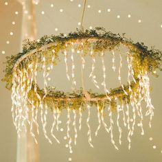 a chandelier with lights hanging from it's sides and greenery on top