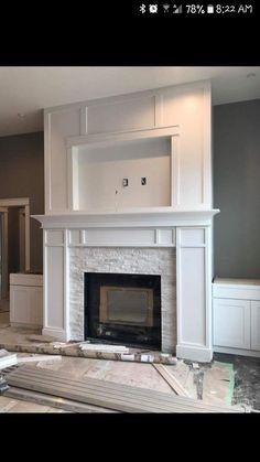 an empty living room with a fireplace and cabinets in the middle of construction work on the floor