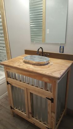 a bathroom with a sink, mirror and wooden cabinet in the corner on the floor