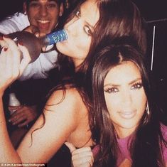 two women and a man are posing for the camera with one woman brushing her teeth