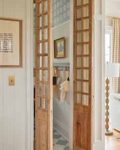 an open door leading to a living room with white walls and wood trimmings