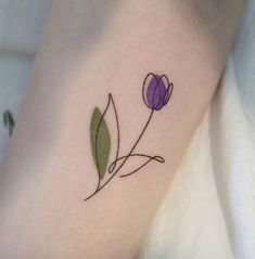 a small flower tattoo on the right thigh and leg, it is purple with green leaves