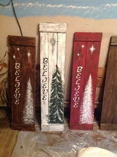 three wooden signs with christmas trees painted on them, one is red and the other is white