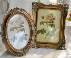 two framed pictures are sitting on a table next to each other, one with a flower in it