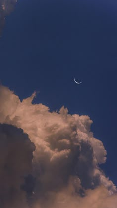 the moon is seen through some clouds on a clear day