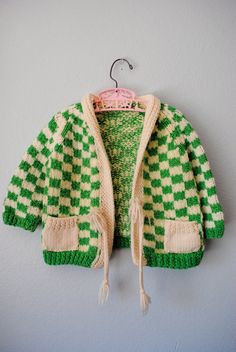 a green and white sweater hanging on a wall