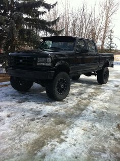 a black pickup truck parked in the snow