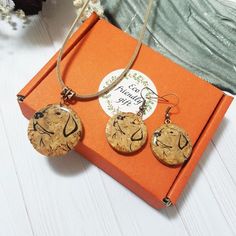 two necklaces are sitting on an orange box