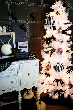 a white christmas tree with black and gold decorations