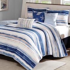 a bed with blue and white comforters in a bedroom