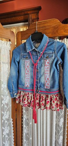 a denim jacket hanging on a clothes rack