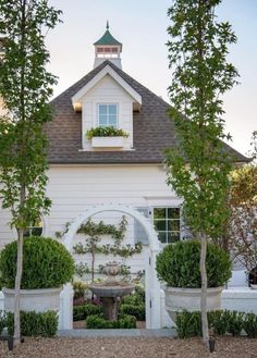 a white house with trees and bushes around it