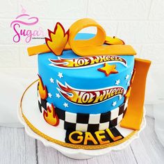 a birthday cake with hot wheels on top and an orange handled tool in the shape of a bag