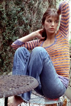 a young woman sitting on top of a metal table