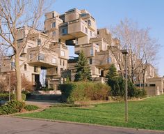 an apartment building with many balconies on the top and trees in the front