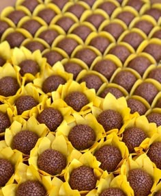 there are many pieces of chocolate cake with yellow decorations on it's sides and in the shape of sunflowers