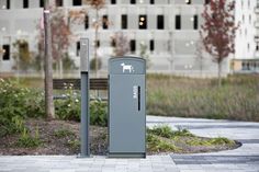 a gray trash can sitting on top of a sidewalk