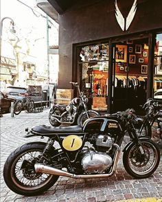 two motorcycles are parked in front of a store