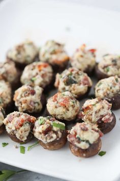 stuffed mushrooms with cheese and herbs on a white plate