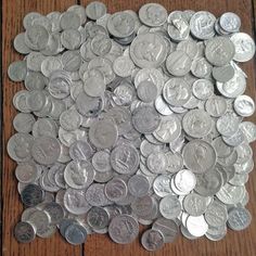 a pile of coins sitting on top of a wooden table