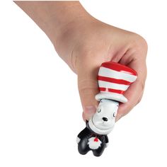 a hand holding a small toy with a cat in the hat on it