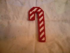 a red and white striped candy cane on a bed with the letter t spelled out