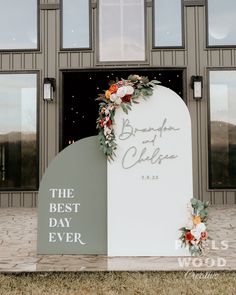 a sign that says the best day ever with flowers on it in front of a building