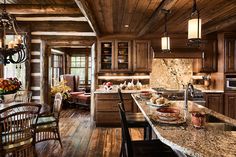 a kitchen with wooden walls and flooring next to a dining room table filled with chairs