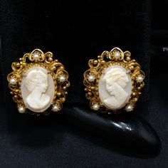 "*Description: This is a beautiful pair of Florenza carved shell earrings in a gold plated filigree frame with small faux pearl accents. The earrings are clip and are signed on the back side of each earring, FLORENZA, with the copyright symbol. These earring \"Ladies\" are each unique and it is obvious they are carved due to the unique features in their faces and the depth of each carving. Each unique cameo is set in gold plated filigree with five faux pearls on each earring. This would be a gre Elegant Carved Earrings For Formal Occasions, Victorian Cameo Earrings For Formal Occasions, Antique Gold Pearl Earrings For Evening, Formal Carved Earrings, Vintage Baroque Earrings For Pierced Ears, Vintage Earrings With Intricate Design, Antique Clip-on Pearl Earrings For Wedding, Ornate Clip-on Earrings For Formal Occasions, Gold Cameo Jewelry For Evening