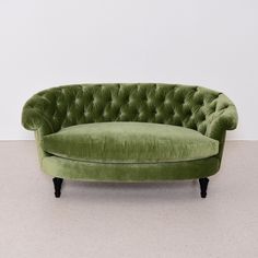 a green couch sitting on top of a white floor