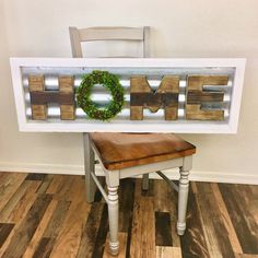 a wooden sign that says home with a wreath on top and a bench underneath it