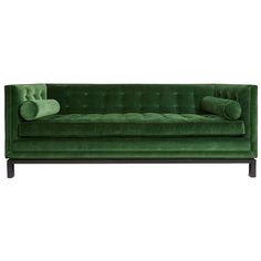 a green velvet couch with two pillows on it's back and one arm facing the camera