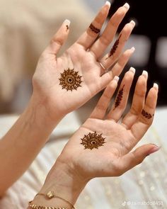 two hands with hendi tattoos on their palms