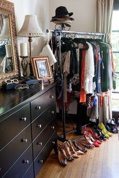 a room with a dresser, mirror and shoes on the floor in front of it