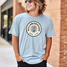 Hillsborough NC hometown t-shirt in 7 colors, perfect for those who want to represent their roots with style. The unisex garment-dyed t-shirt offers a relaxed fit and classic crew neckline, suitable for casual or semi-formal settings. Ideal for locals, tourists, and proud Hillsborough residents, this t-shirt is great for everyday wear or as a thoughtful gift. Celebrate your hometown pride on holidays, community events, or casual outings. Product features - Available in sizes S to 4XL - Double-needle stitching for durability - Without side seams for a clean look - Garment-dyed fabric for softness - Made with 100% US cotton for comfort Care instructions - Machine wash: cold (max 30C or 90F) - Do not bleach - Tumble dry: low heat - Iron, steam or dry: low heat - Do not dryclean ** Please note North Carolina Gifts, Hometown Pride, Community Events, Dye T Shirt, Semi Formal, Crew Neckline, San Jose, Halloween Shopping, North Carolina