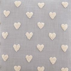 a gray pillow with white hearts on it