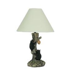 a lamp that is on top of a tree stump with a cat sitting on it