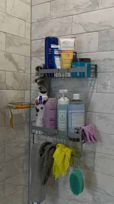 a shower shelf filled with personal care products and cleaning supplies next to a tiled wall