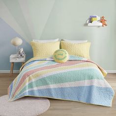 a child's bedroom with blue walls and striped bedspread on the bed