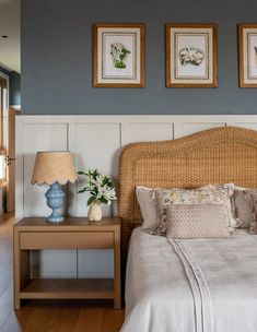 a bed sitting in a bedroom next to two framed pictures on the wall above it