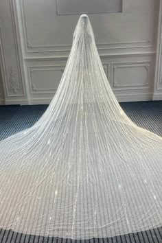 a very long white veil sitting on top of a floor