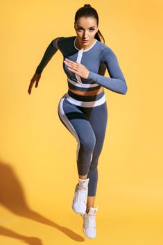 a woman in grey and white outfit running