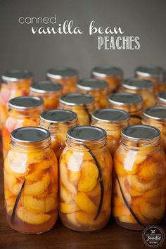 jars filled with sliced peaches sitting on top of a table